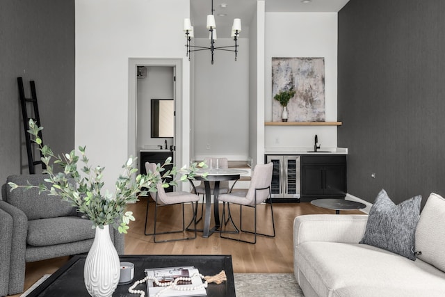 living room featuring hardwood / wood-style flooring, sink, beverage cooler, and a chandelier