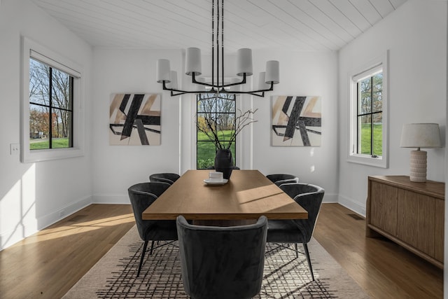 dining area with a notable chandelier, dark hardwood / wood-style floors, and wood ceiling