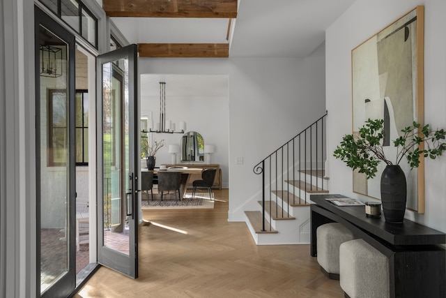 foyer featuring plenty of natural light, beam ceiling, parquet flooring, and french doors