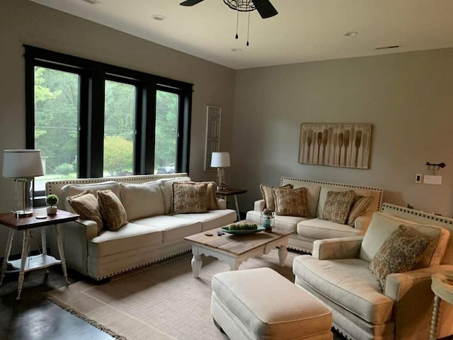 living room featuring ceiling fan and concrete flooring