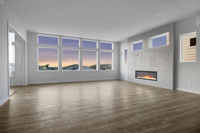 unfurnished living room with a healthy amount of sunlight and wood-type flooring