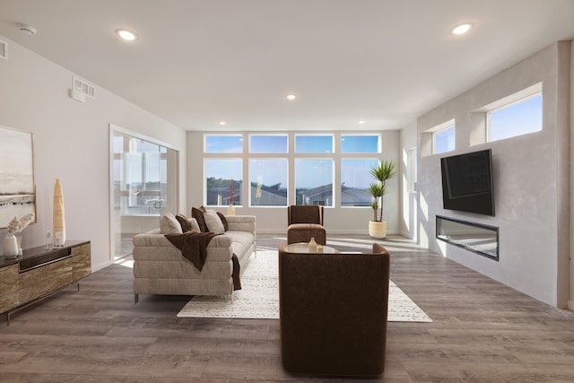 living room with a wealth of natural light and dark wood-type flooring