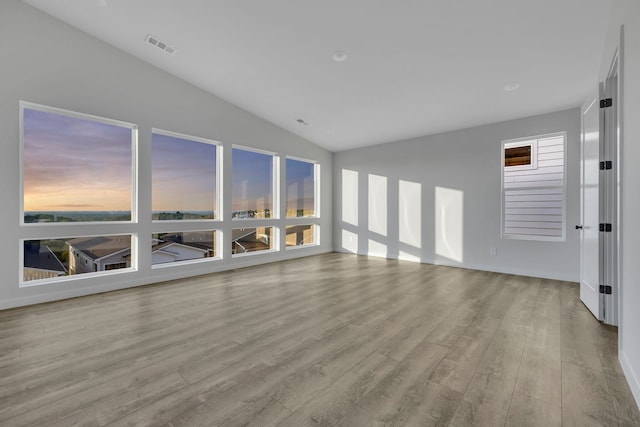 unfurnished living room with vaulted ceiling and light hardwood / wood-style flooring