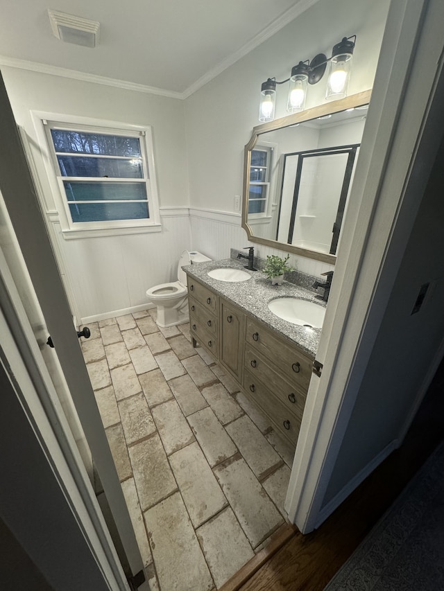 bathroom featuring ornamental molding, vanity, and toilet