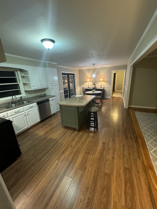 kitchen with sink, a center island, hanging light fixtures, dishwasher, and white cabinets