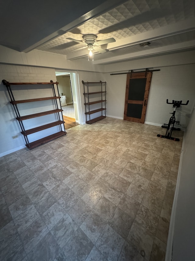 basement featuring a barn door and ceiling fan