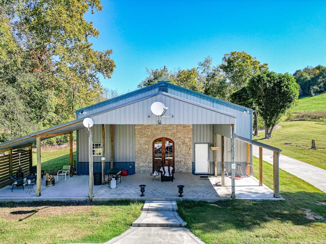 view of front facade featuring a patio, a front yard, and french doors