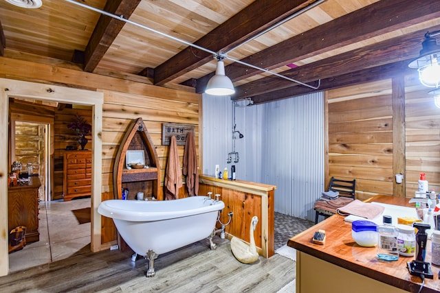 bathroom featuring hardwood / wood-style floors, beam ceiling, a bath, and wood walls