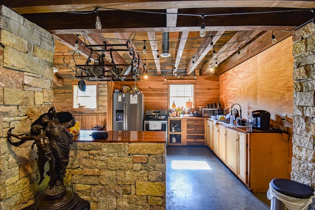 kitchen with beamed ceiling, a wealth of natural light, appliances with stainless steel finishes, and concrete floors