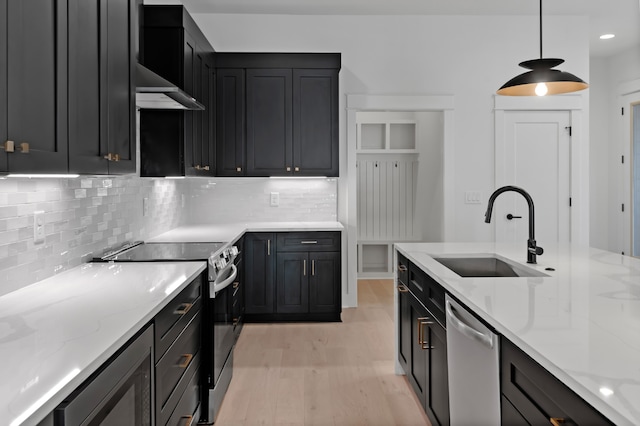 kitchen featuring decorative light fixtures, light stone counters, sink, and appliances with stainless steel finishes