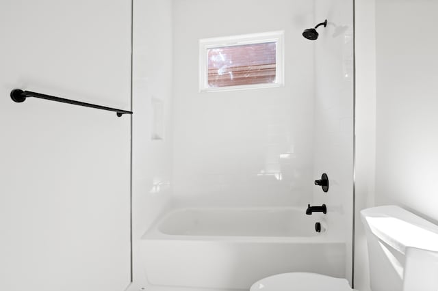 bathroom featuring toilet and tiled shower / bath