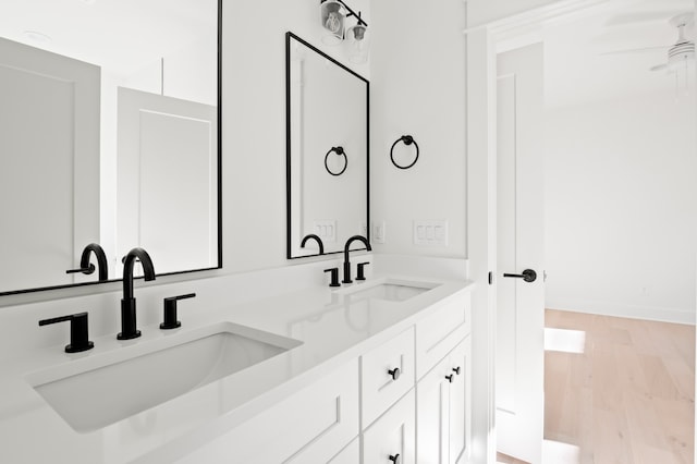 bathroom with wood-type flooring, vanity, and ceiling fan