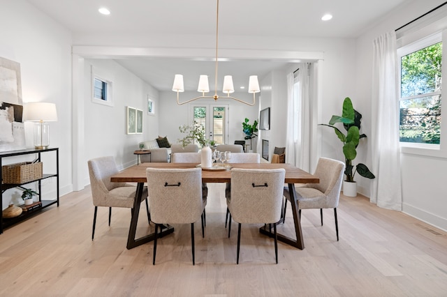 dining area featuring light hardwood / wood-style flooring and an inviting chandelier