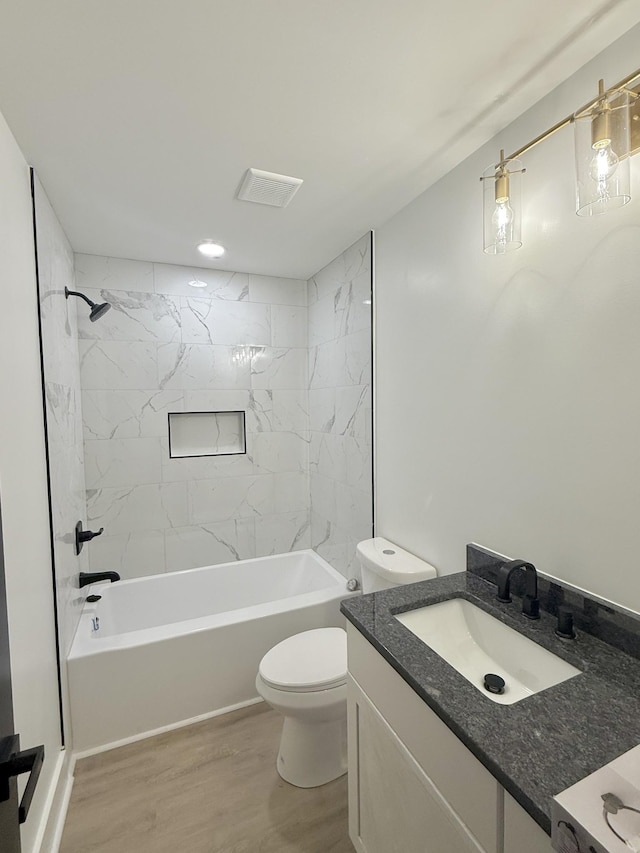 full bathroom with vanity, toilet, wood-type flooring, and tiled shower / bath combo