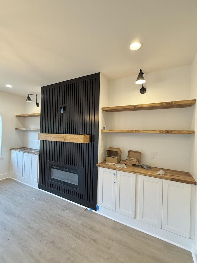 interior space featuring wooden counters, light hardwood / wood-style flooring, and white cabinetry