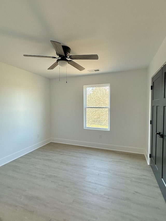 empty room with light hardwood / wood-style flooring and ceiling fan