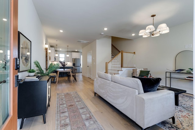 living room with light hardwood / wood-style flooring and a notable chandelier