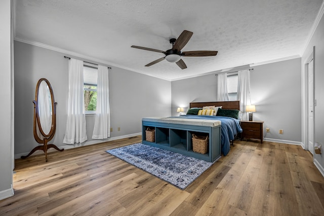 bedroom with ornamental molding, light hardwood / wood-style floors, and a textured ceiling