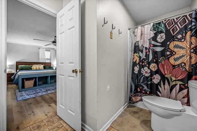 bathroom featuring a shower with shower curtain, ceiling fan, and toilet