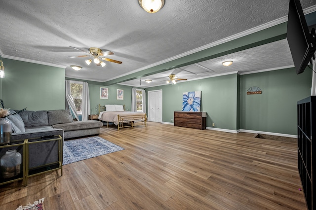 living room with hardwood / wood-style flooring, ceiling fan, and crown molding