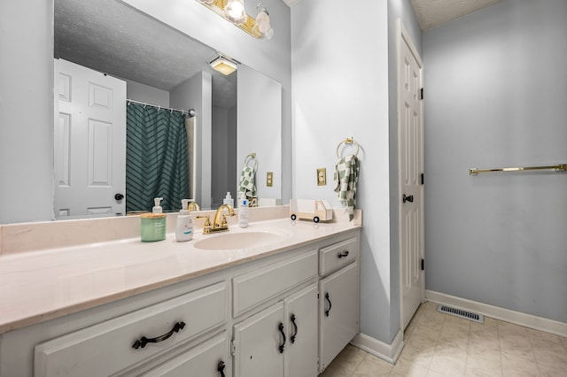 bathroom with a shower with curtain, vanity, and a textured ceiling