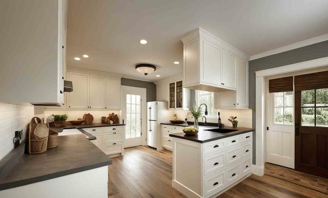 kitchen featuring white cabinetry, crown molding, and hardwood / wood-style flooring