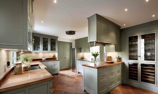 kitchen featuring tasteful backsplash, wood counters, kitchen peninsula, and wine cooler