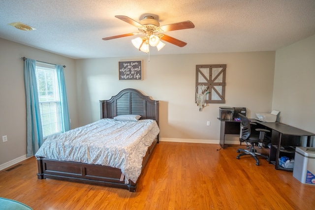 bedroom featuring ceiling fan, a textured ceiling, and hardwood / wood-style flooring