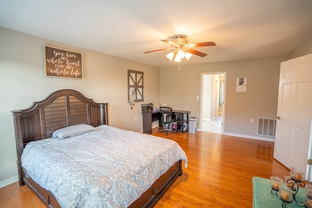 bedroom featuring a textured ceiling, light hardwood / wood-style floors, and ceiling fan