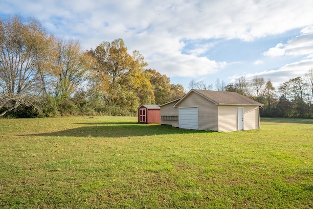 view of yard with an outdoor structure, a detached garage, and a storage shed