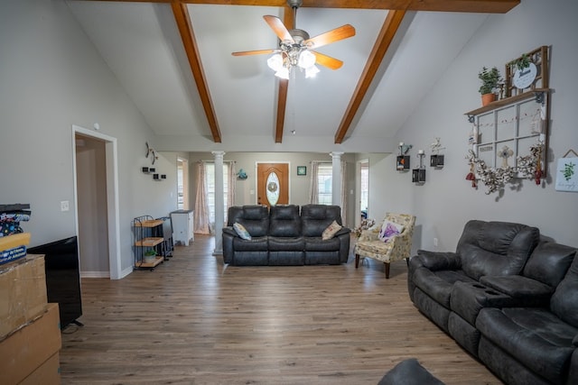 living room featuring vaulted ceiling with beams, hardwood / wood-style flooring, and ornate columns