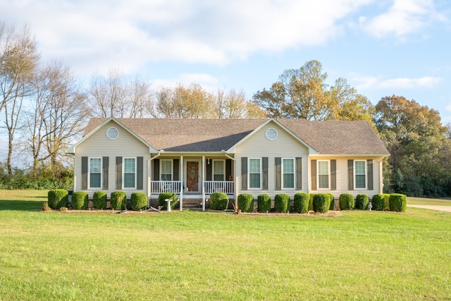 single story home featuring covered porch, a shingled roof, and a front yard