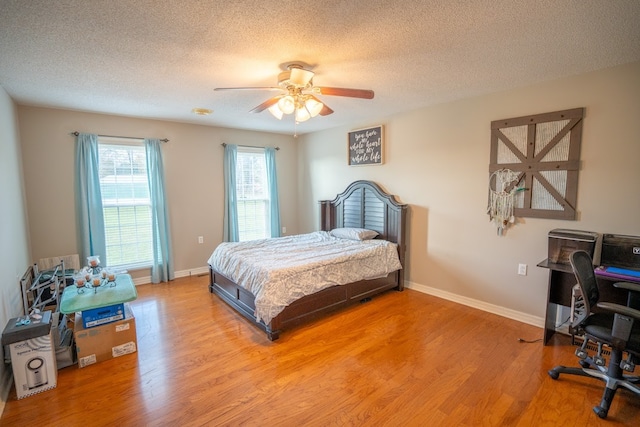 bedroom featuring a textured ceiling, light wood-type flooring, and ceiling fan