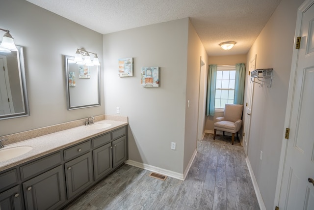 bathroom with vanity, a textured ceiling, and hardwood / wood-style flooring