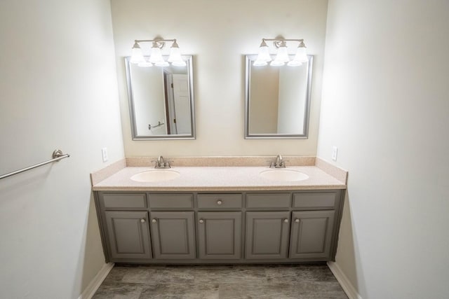 bathroom with double vanity, baseboards, and a sink