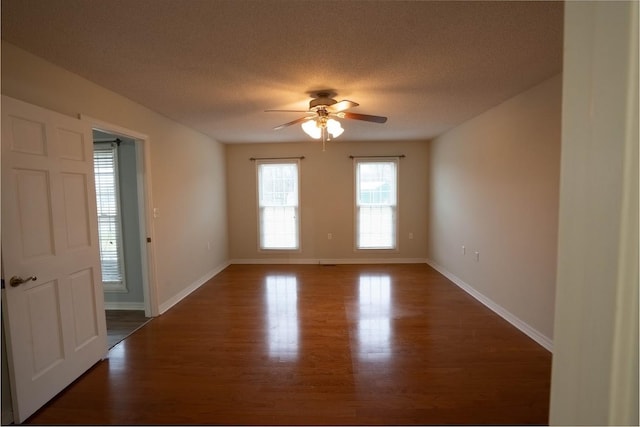 unfurnished room featuring ceiling fan, a textured ceiling, baseboards, and wood finished floors