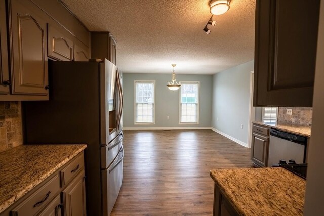 kitchen featuring tasteful backsplash, dishwasher, stainless steel fridge with ice dispenser, and dark wood-style floors