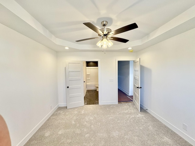 unfurnished bedroom featuring recessed lighting, a ceiling fan, baseboards, carpet, and a raised ceiling