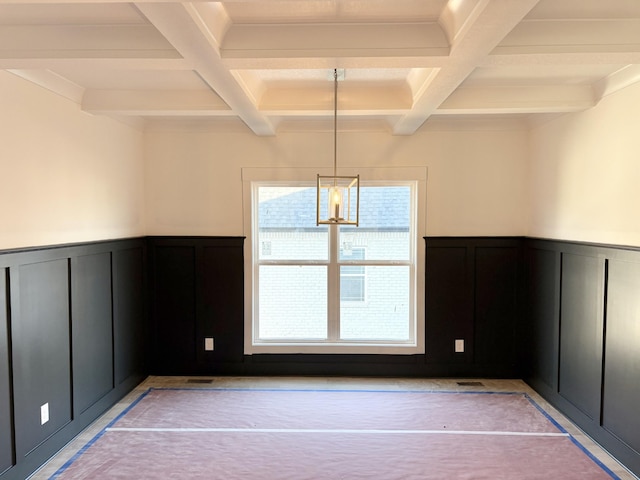 unfurnished room with a wainscoted wall, beamed ceiling, coffered ceiling, and a decorative wall