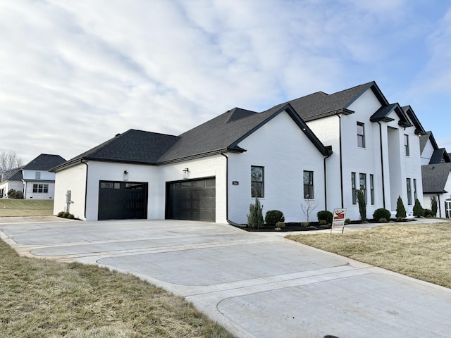 view of side of property featuring concrete driveway, brick siding, a lawn, and an attached garage