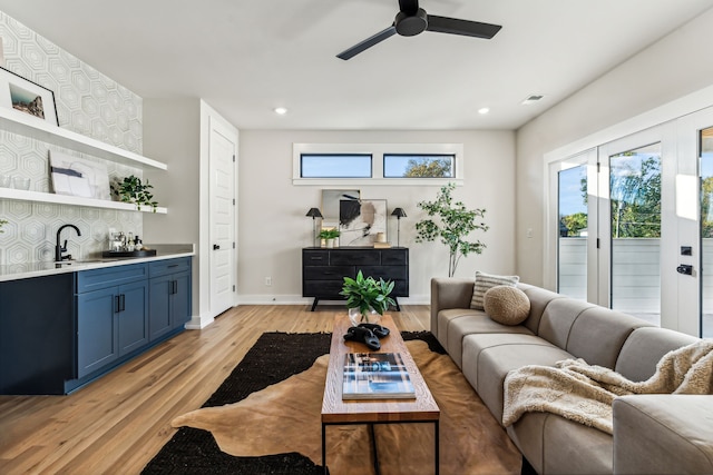 living room with ceiling fan, light hardwood / wood-style flooring, plenty of natural light, and sink