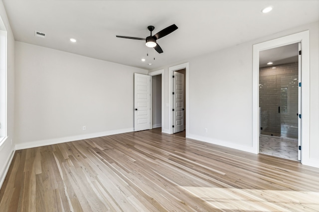 unfurnished bedroom featuring light hardwood / wood-style flooring, ensuite bath, and ceiling fan