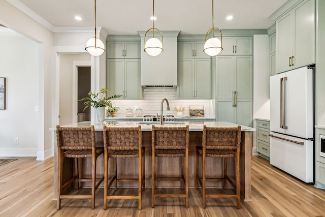 kitchen featuring decorative backsplash, wood-type flooring, decorative light fixtures, and high end fridge