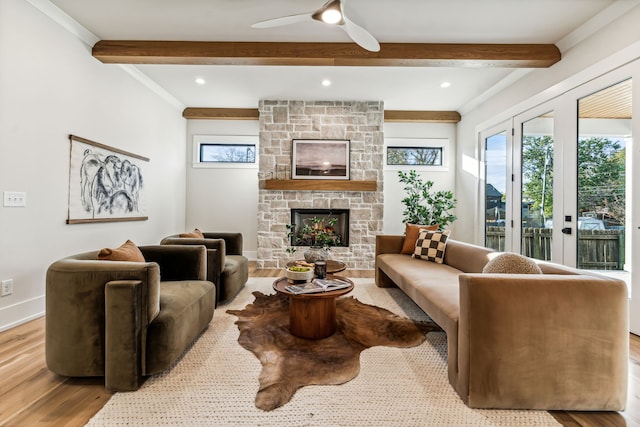 living room with a fireplace, french doors, beamed ceiling, and light wood-type flooring