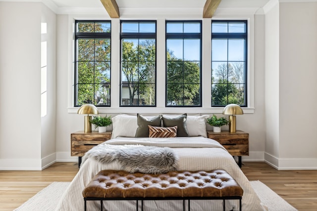 bedroom featuring beamed ceiling and light hardwood / wood-style flooring