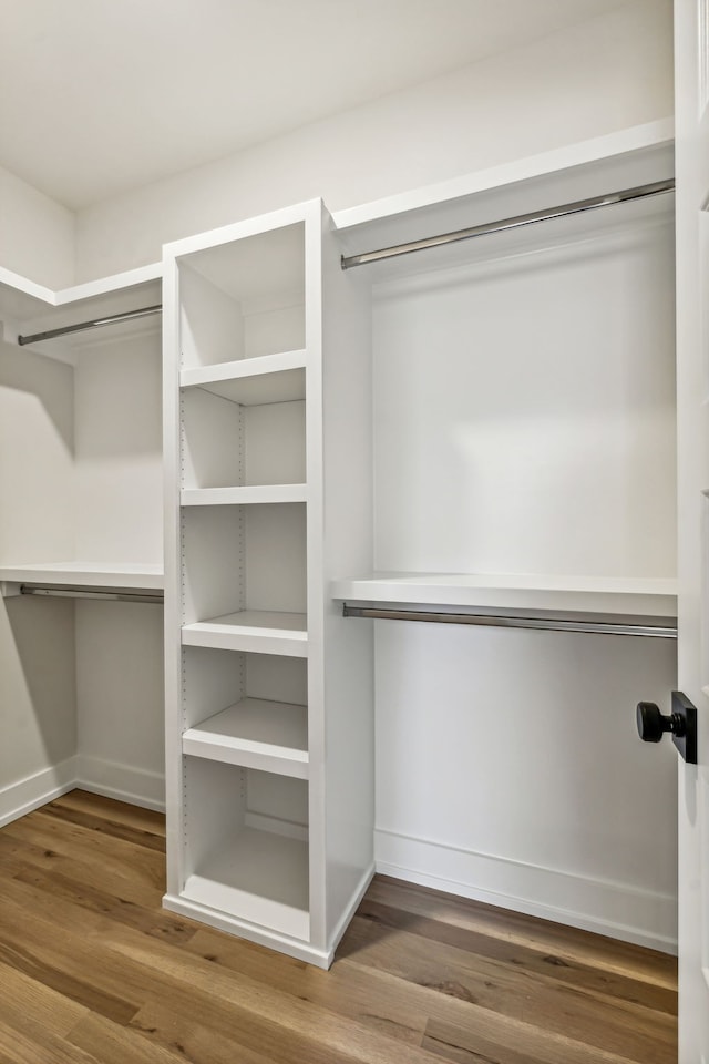 walk in closet with hardwood / wood-style floors