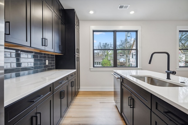 kitchen featuring sink, a healthy amount of sunlight, stainless steel dishwasher, and light hardwood / wood-style floors