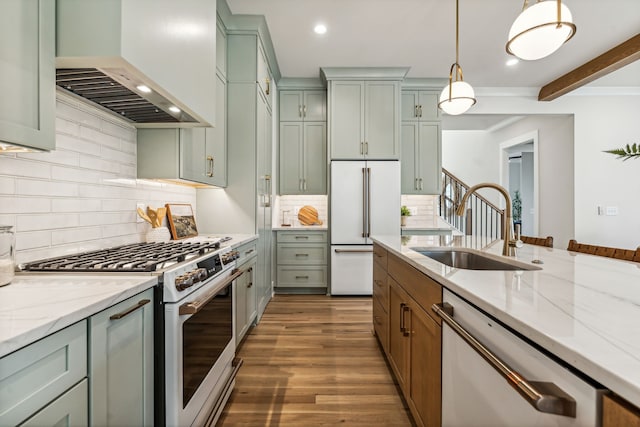 kitchen featuring high quality appliances, premium range hood, sink, hanging light fixtures, and dark hardwood / wood-style floors