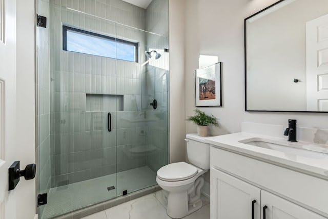 bathroom with vanity, toilet, and a shower with shower door