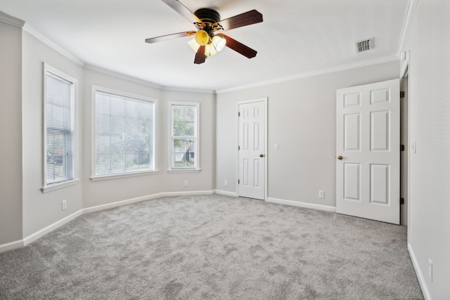 carpeted empty room featuring ceiling fan and crown molding